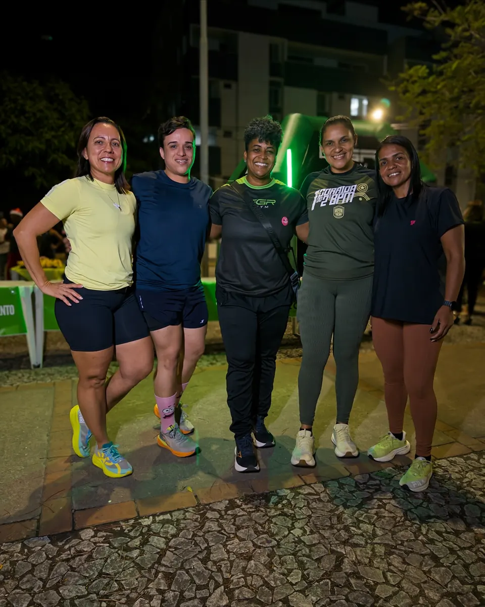 Team and participants of EGR in Action, at night, in front of the EGR GYM entrance arch