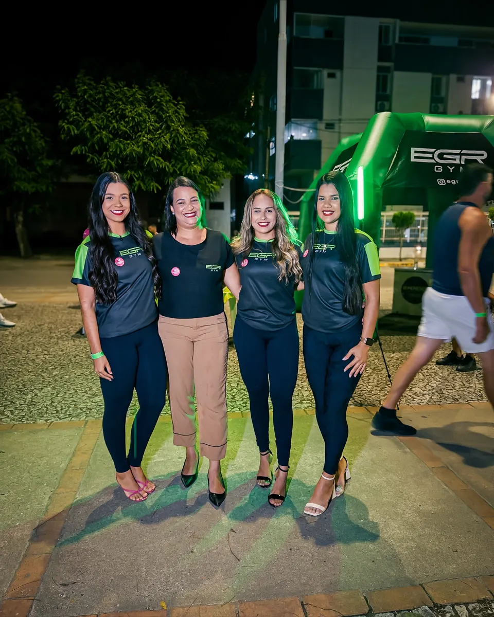 Team and participants of EGR in Action, at night, in front of the EGR GYM entrance arch