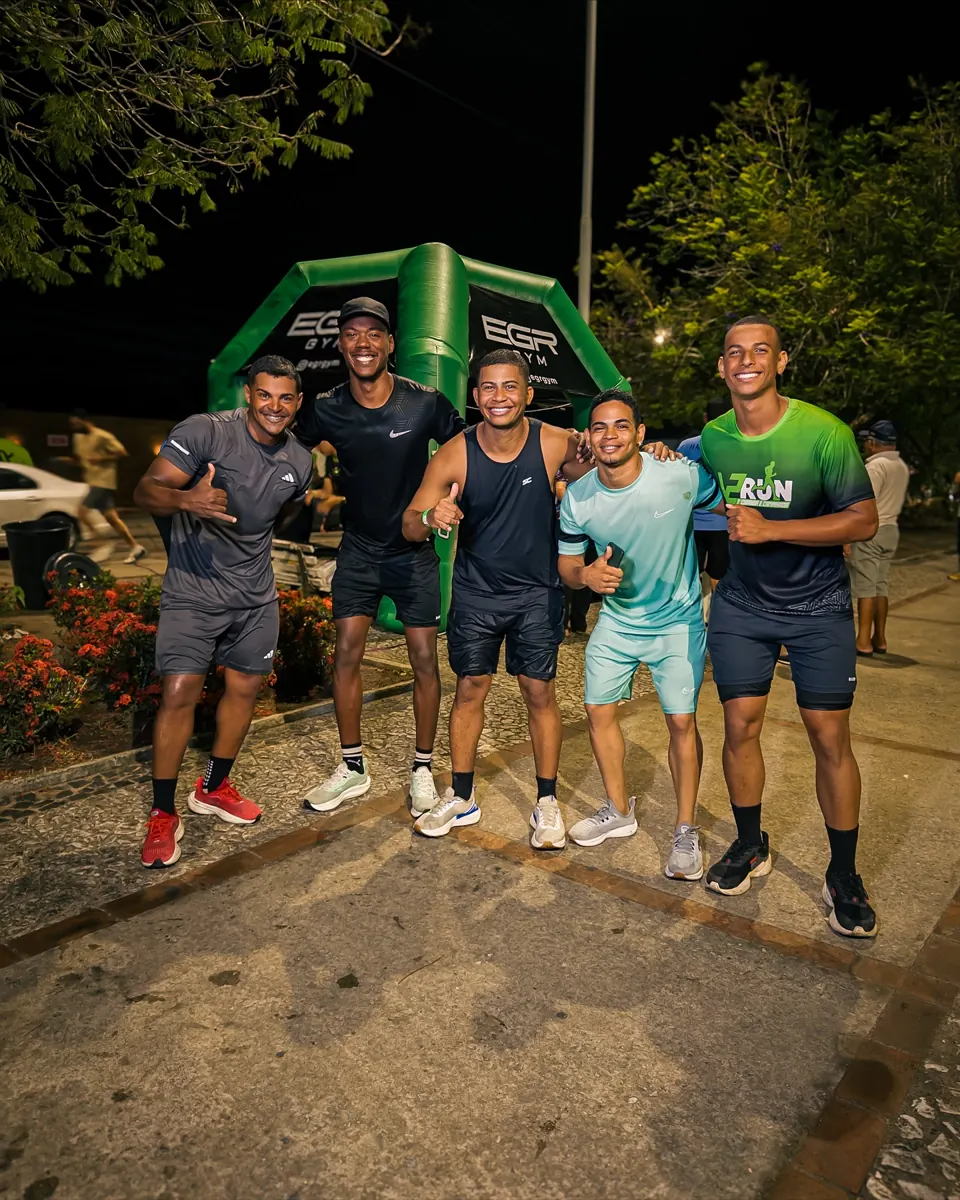 Team and participants of EGR in Action, at night, in front of the EGR GYM entrance arch