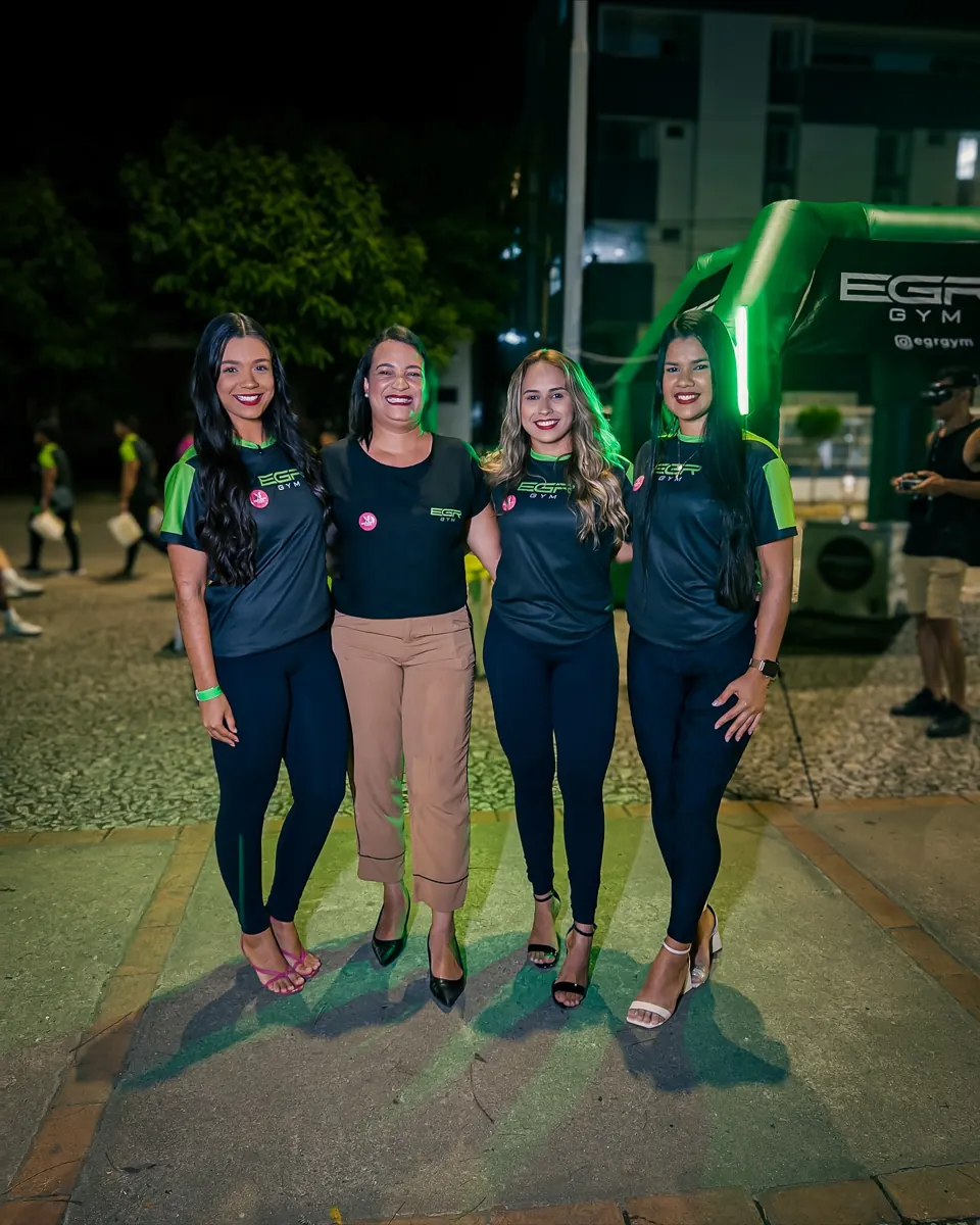 Team and participants of EGR in Action, at night, in front of the EGR GYM entrance arch