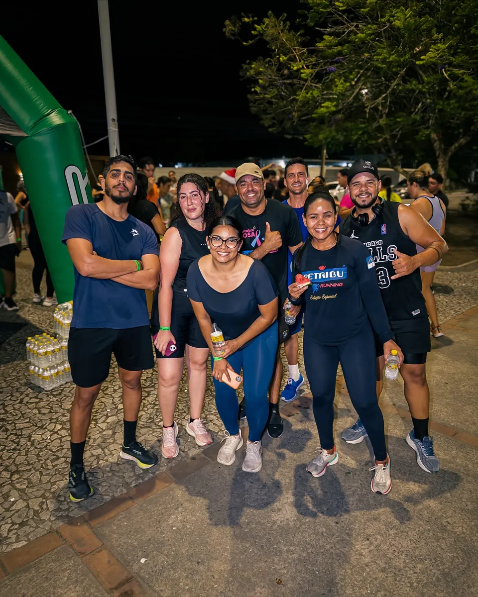 Team and participants of EGR in Action, at night, in front of the EGR GYM entrance arch