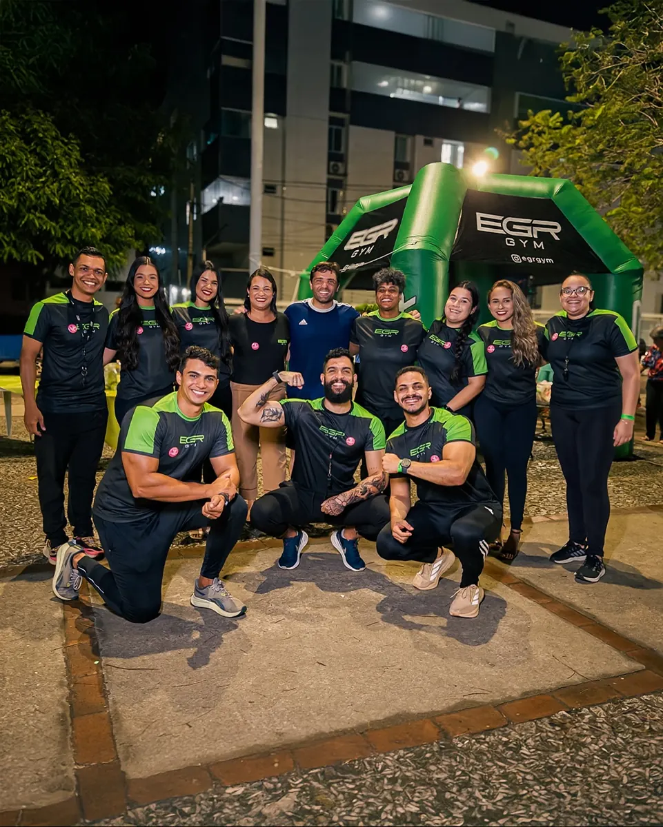 Team and participants of EGR in Action, at night, in front of the EGR GYM entrance arch