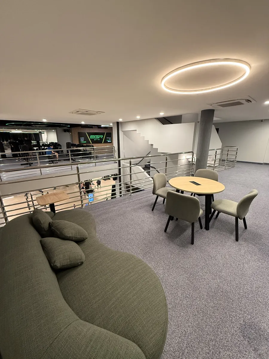 Lounge com sofá e mesas no mezanino